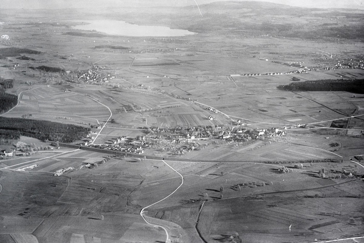 Die Ebene nördlich des Greifensees war vor 100 Jahren dominiert von Mooren und Riedwiesen. Im oberen Drittel rechts sind die Gebäude des Flughafens Dübendorf zu sehen. Die Flugzeuge landeten noch auf der Wiese. © e-pics ETH-BIB, Walter Mittelholzer 1919